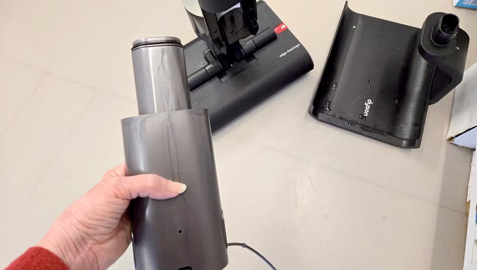 hand holding a detachable battery of the dyson washg1 wet floor cleaner