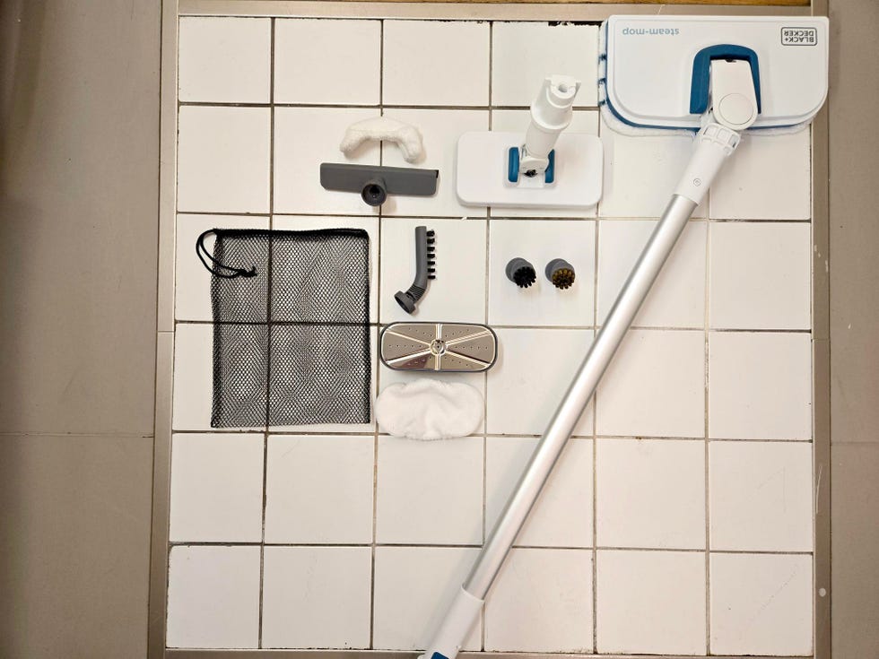 black and decker on a tile floor next to its various attachments