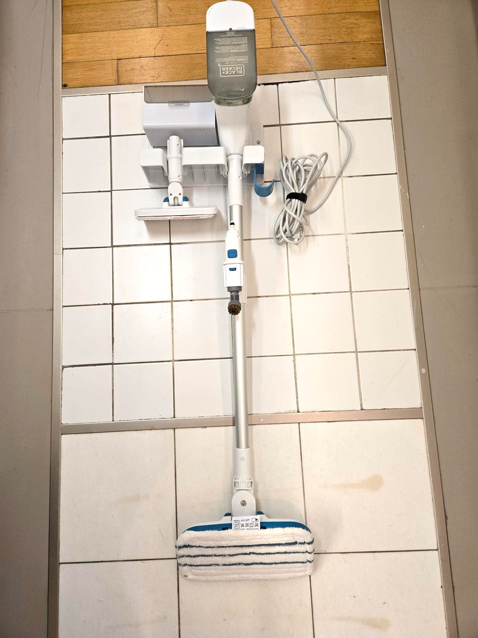 black and decker steam cleaner in wall caddy laying on a tiled floor