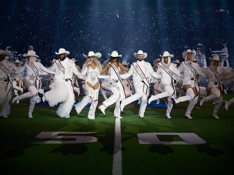 a choreographed performance featuring dancers in matching outfits on a football field