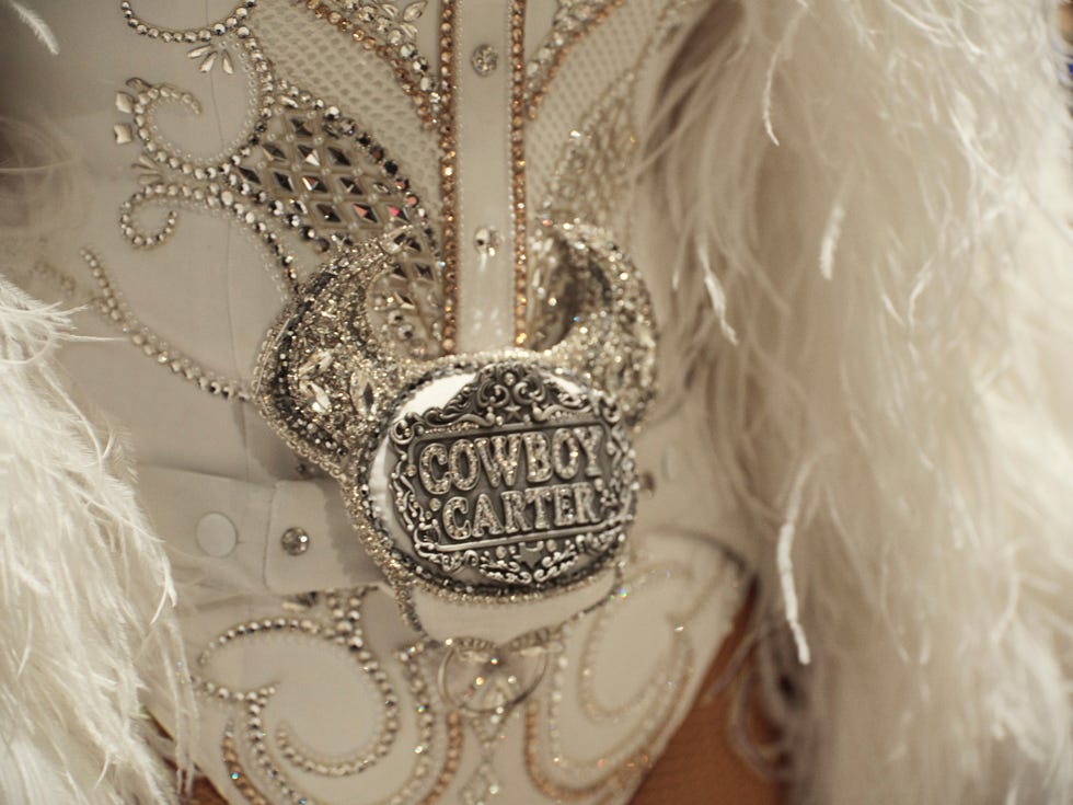 a detailed closeup of a cowboy costume featuring elaborate embellishments and a belt buckle