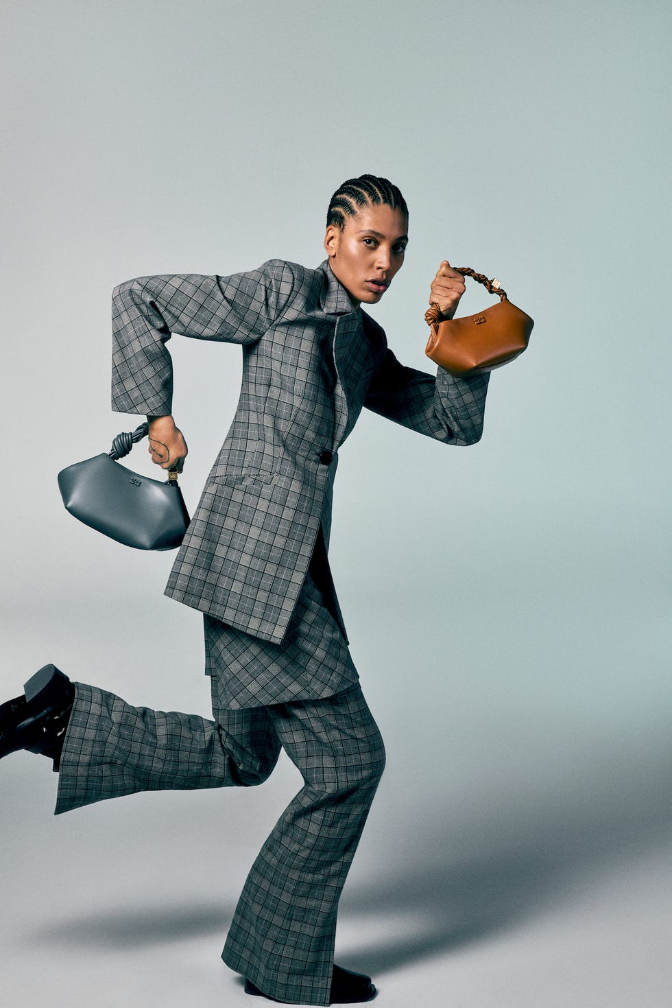 a person in a checkered suit running while holding two handbags