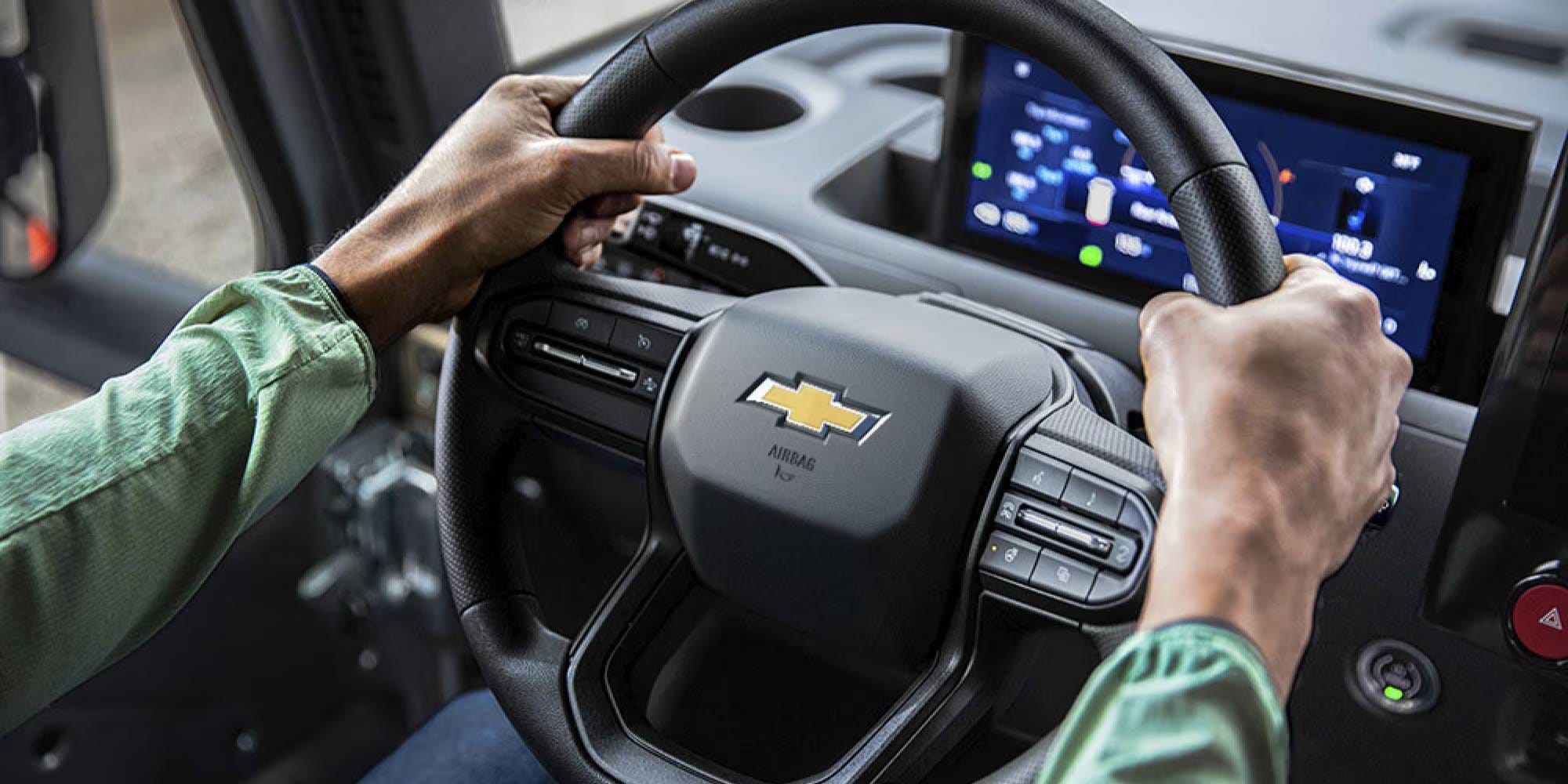 Interior view of a vehicle with a display screen and driver's seat.