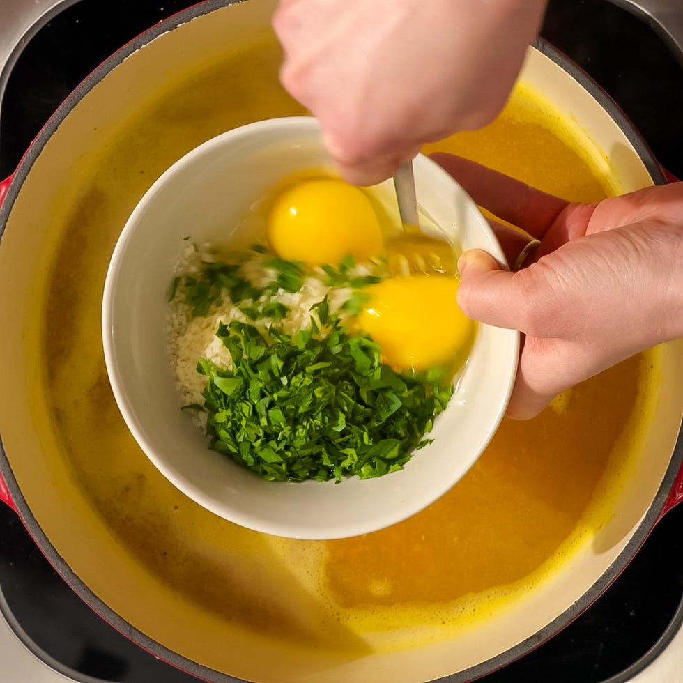mixing ingredients for a recipe in a bowl above a pot of soup