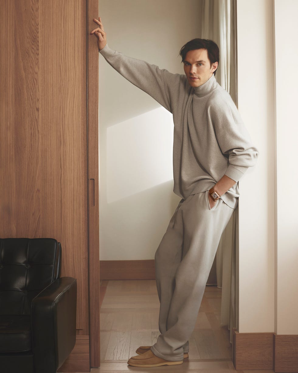 person leaning against a door frame in a softly lit room