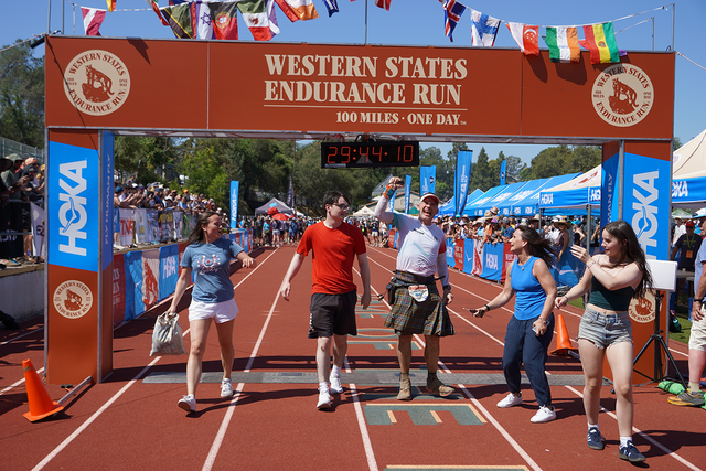 group of people on a track celebrating at a finish line