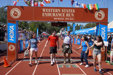 group of people on a track celebrating at a finish line