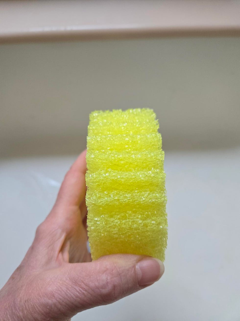 yellow scrub daddy cleaning sponge held in a hand