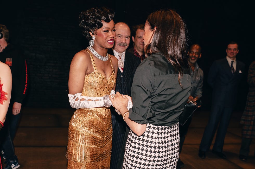 a group of elegantly dressed individuals engaged in conversation at a social event