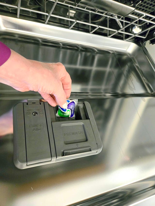 best dishwasher tablets inserting a dishwasher pack into the dispenser