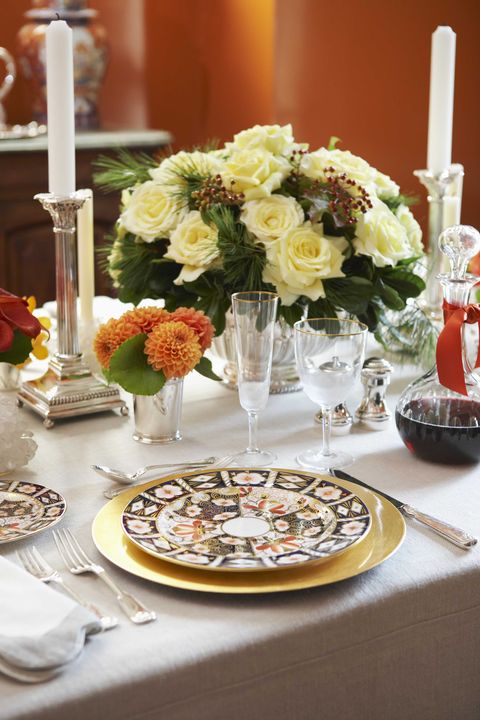 a table with a white tablecloth set with an autumnal color palette