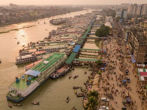 De grootste veerterminal van Dhaka de hoofdstad van Bangladesh is het brandpunt van de verkeersdrukte op de rivier de Buriganga Het achttien miljoen inwoners tellende Dhaka is kwetsbaar voor overstromingen en zwelt elk jaar aan door de komst van honderdduizenden migranten vooral uit kustgebieden die door erosie en de stijgende zeespiegel onbewoonbaar zijn geworden