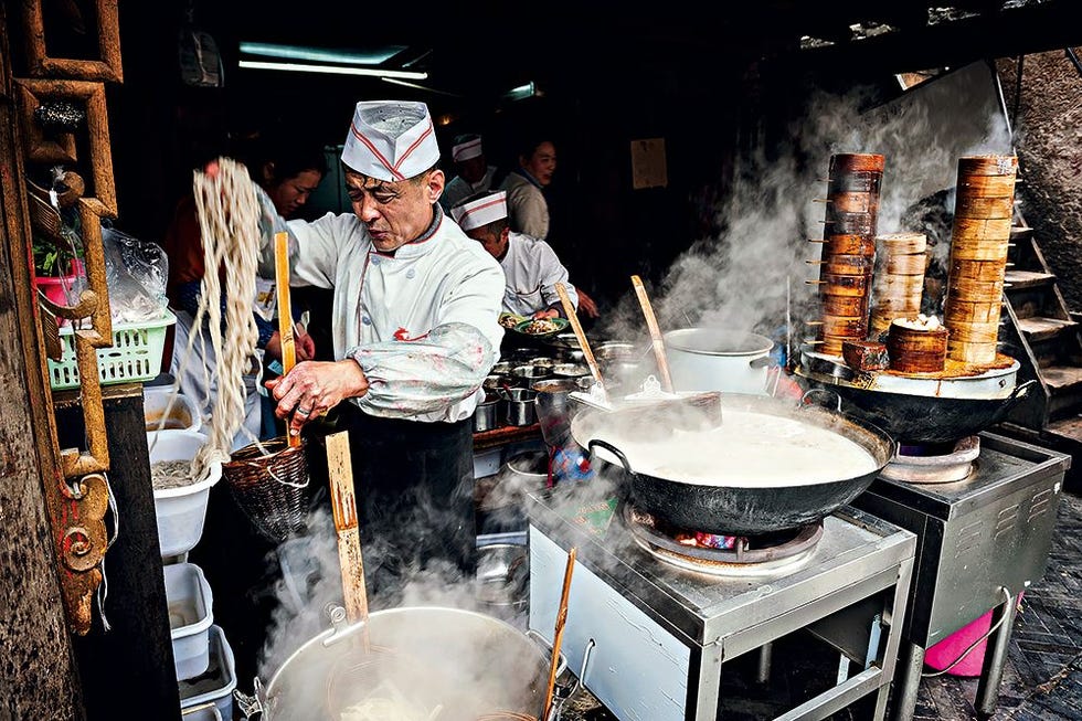 Koks in het centrum van Chengdu maken een aantal specialiteiten klaar waaronder zoetzure rijstnoedels en gestoomde dumplings