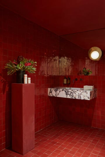 a bathroom with a red tile floor