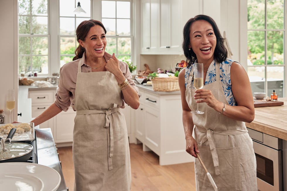 Cooks engaged in food preparation in a modern kitchen.