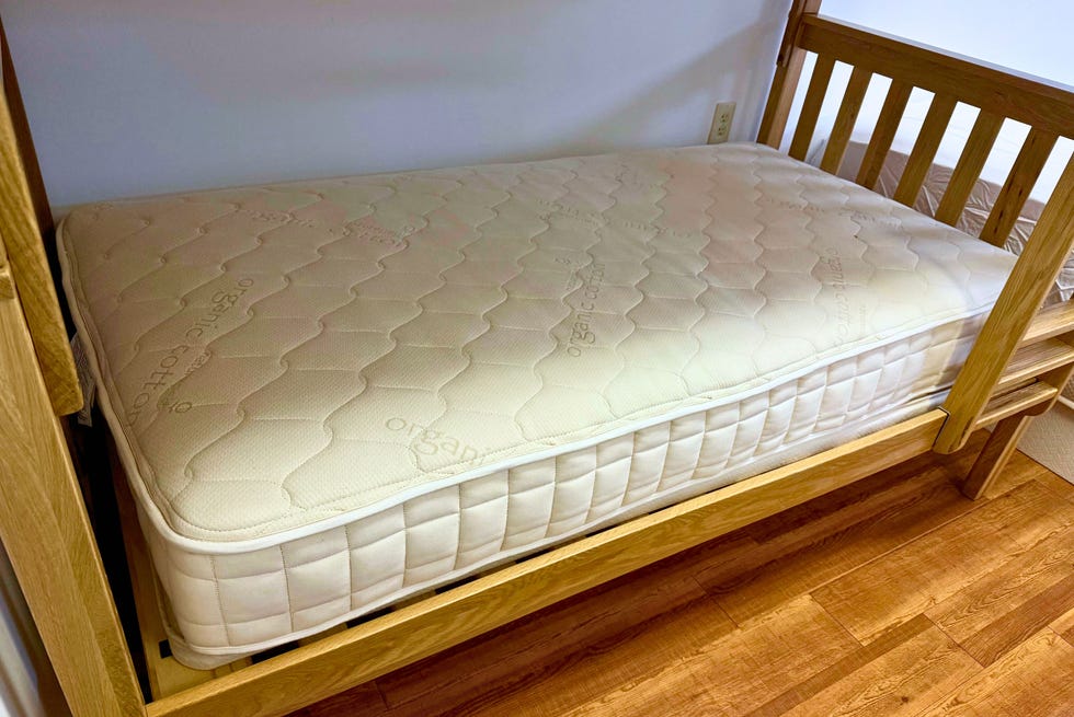 best kids mattresses - naturepedic a naturepedic kids mattress on a wooden bunk bed frame