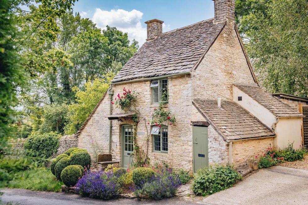 stone cottage with lush garden and trees