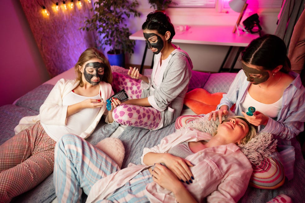 young female friends getting beauty treatments together at a sleepover party