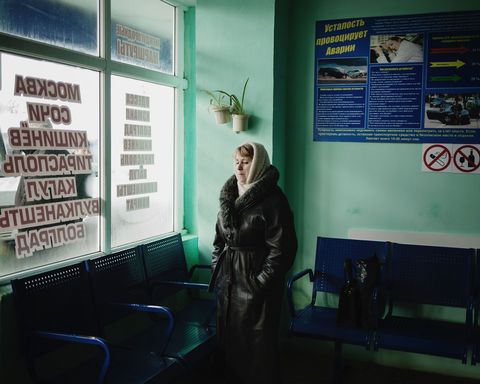 Een vrouw staat te wachten op het hoofdbusstation waar bussen vertrekken naar andere delen van Moldavi en naar Rusland en Transnistri
