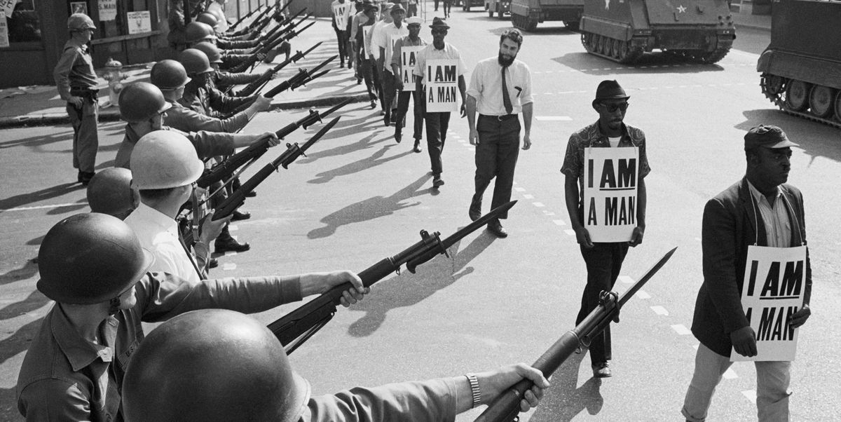 us national guard troops block off beale street as civil rights marchers wearing placards reading, "i am a man" pass by on march 29, 1968 it was the third consecutive march held by the group in as many days rev martin luther king, jr, who had left town after the first march, would soon return and be assassinated