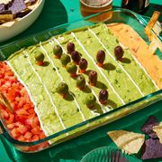 football field decorated layered dip with refried beans, sour cream, pico de gallo, guacamole, and queso