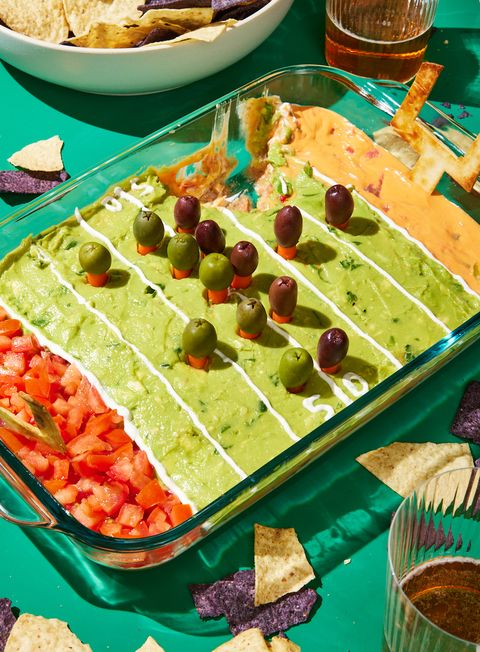 football field decorated layered dip with refried beans, sour cream, pico de gallo, guacamole, and queso