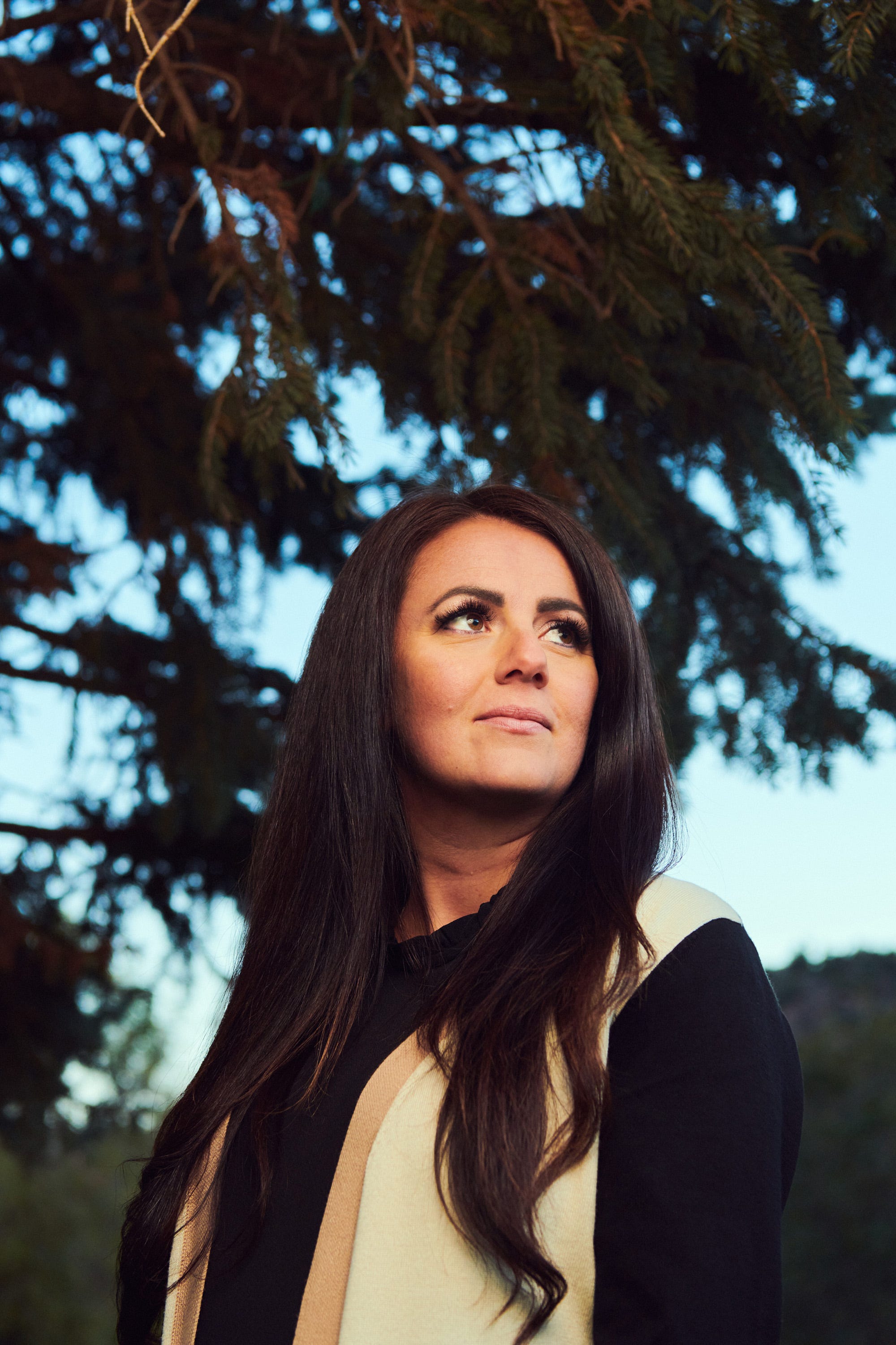 a woman standing under a tree