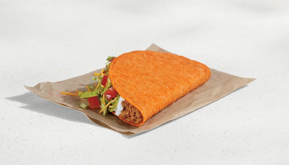 taco filled with meat lettuce tomatoes and sauce in a bright orange shell