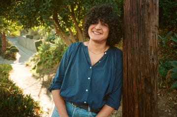 person leaning against a wooden pole in a natural setting