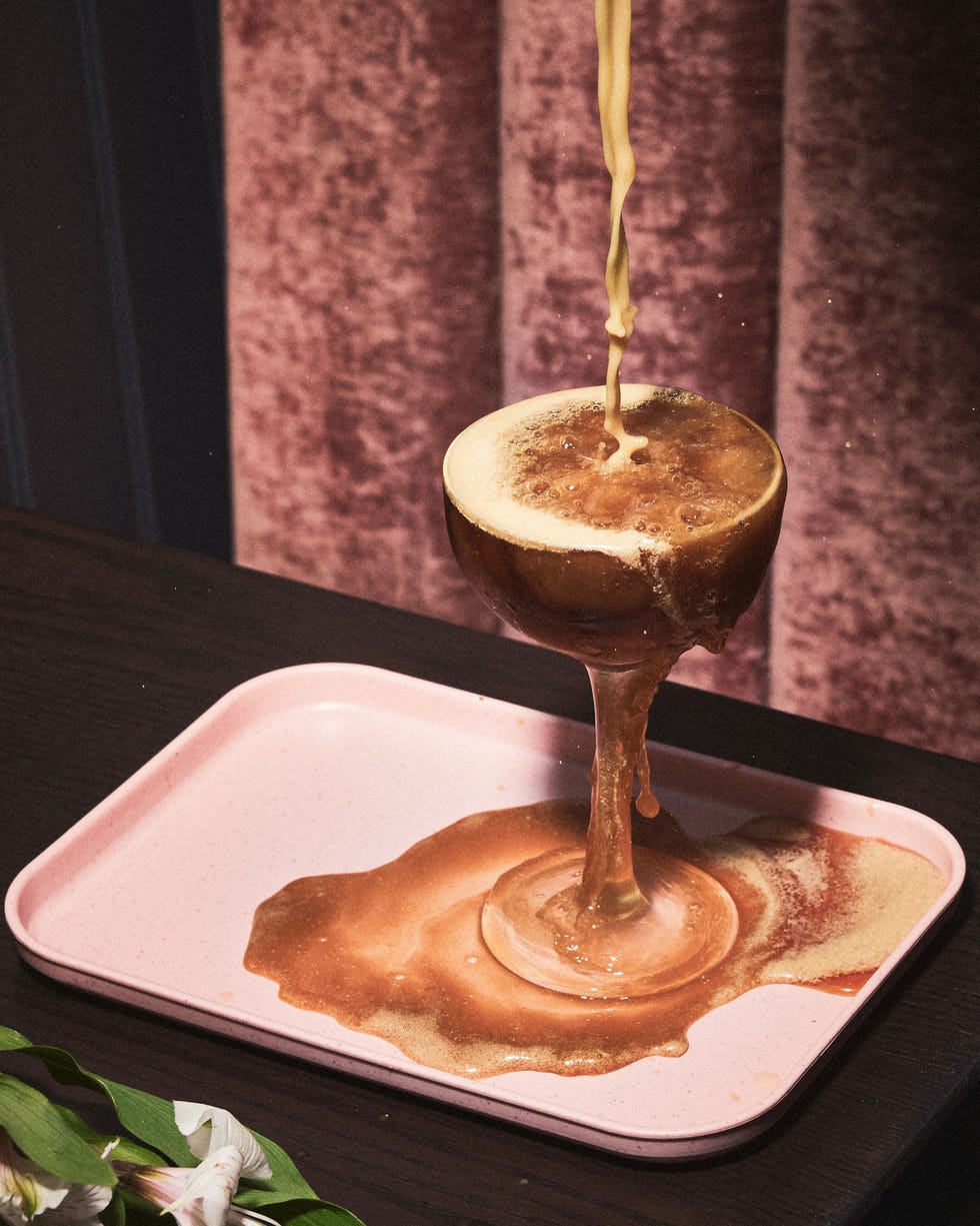a glass with brown liquid and a brown liquid in it