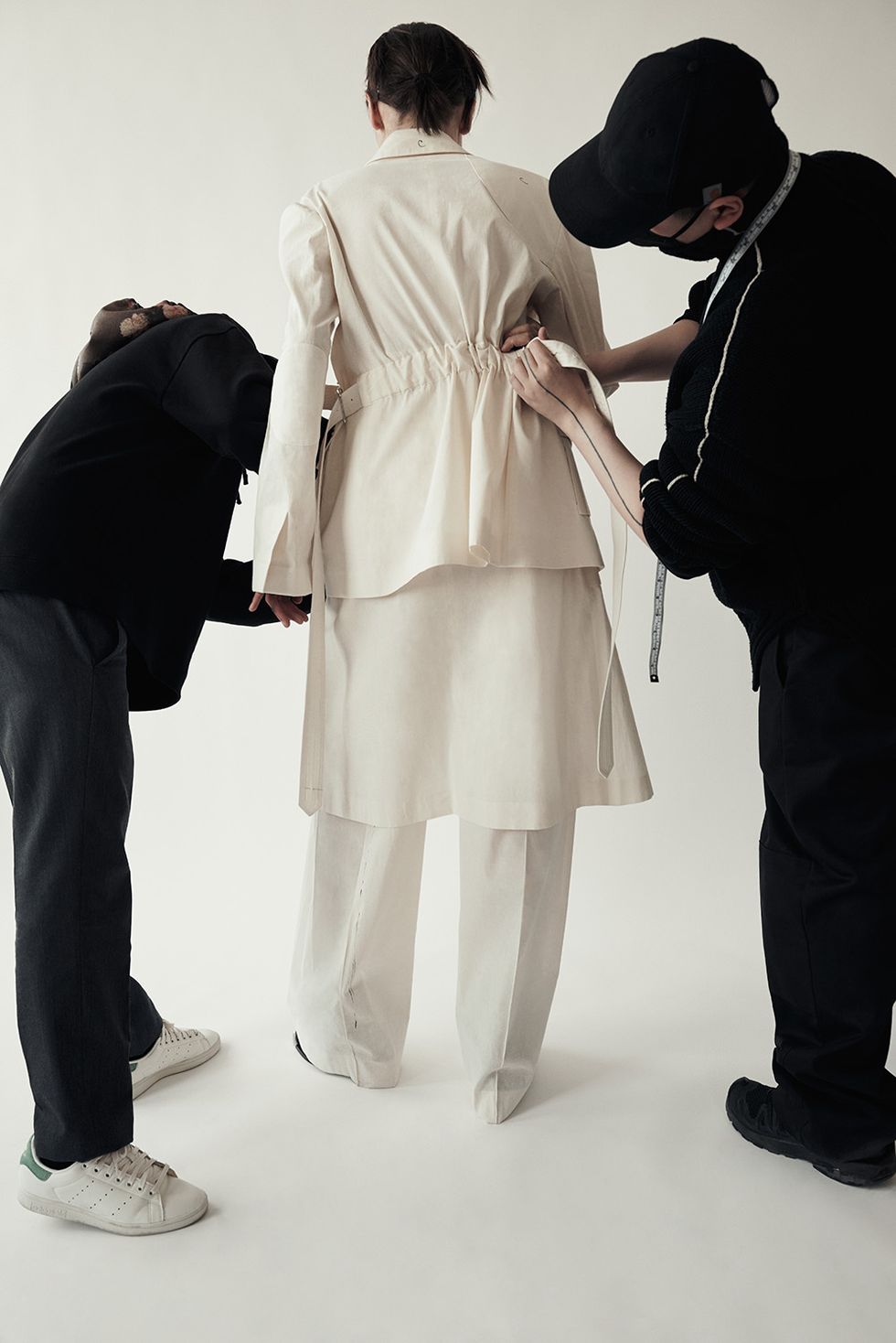 a photo of peter do and another designer fitting a coat on a mannequin from upcoming designer collaborations