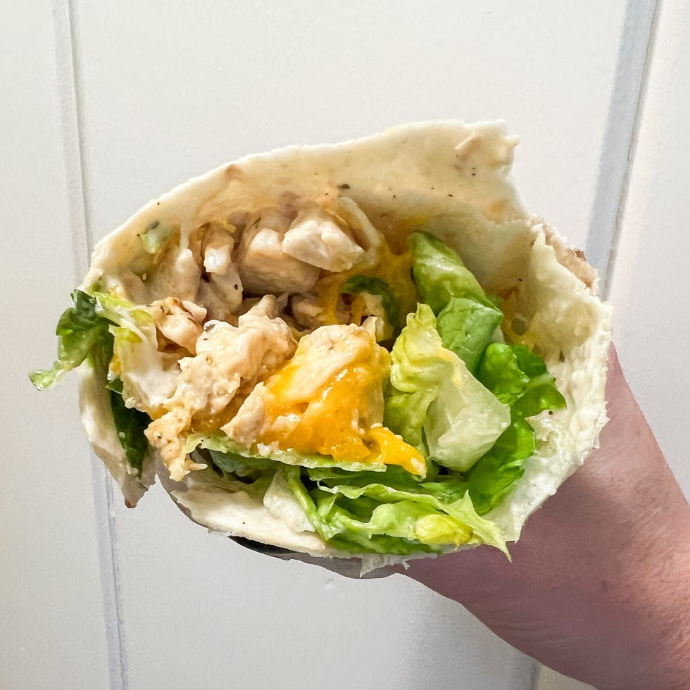 hand holding chicken lettuce wrap cut in half