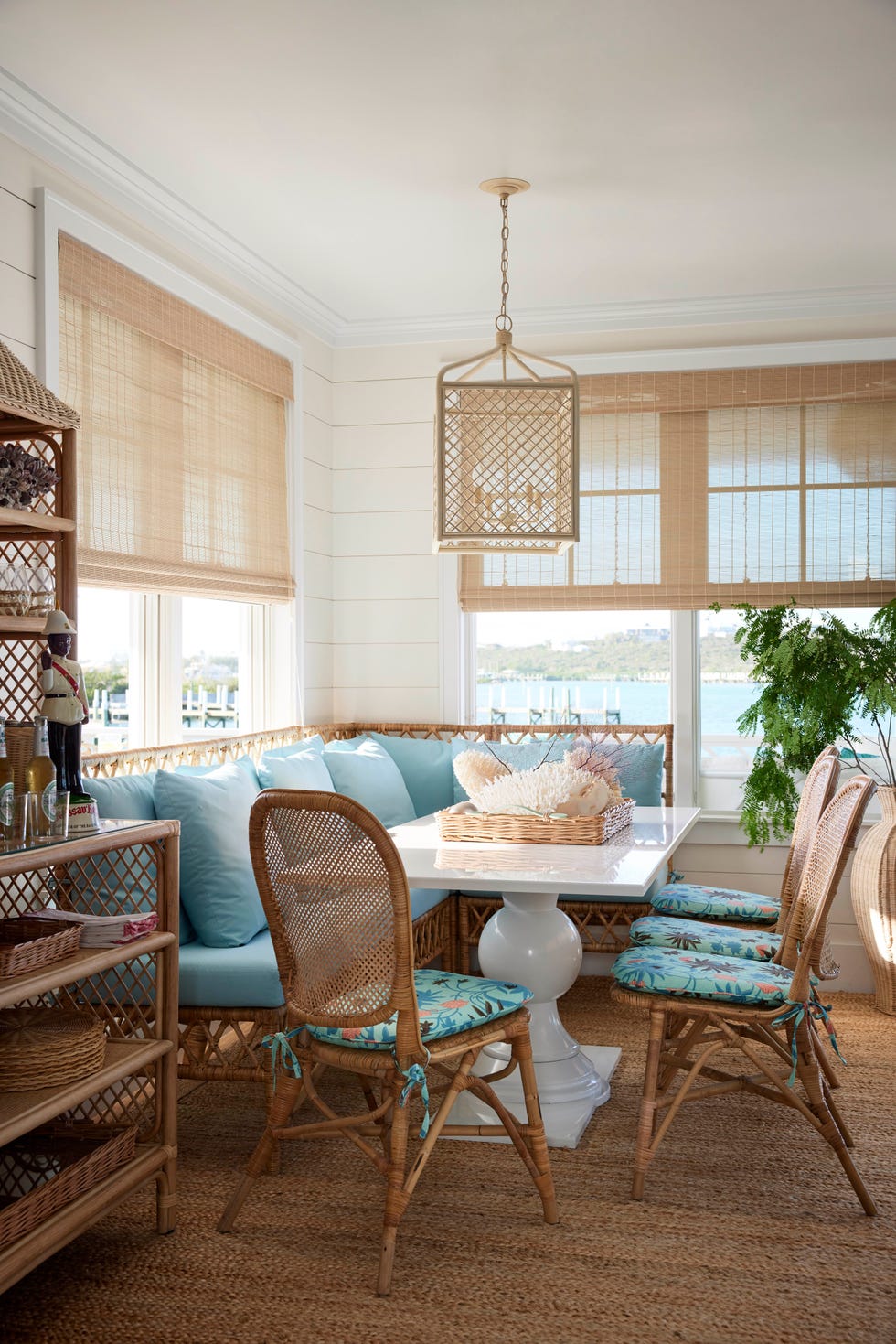 a dining room with a table and rattan chairs