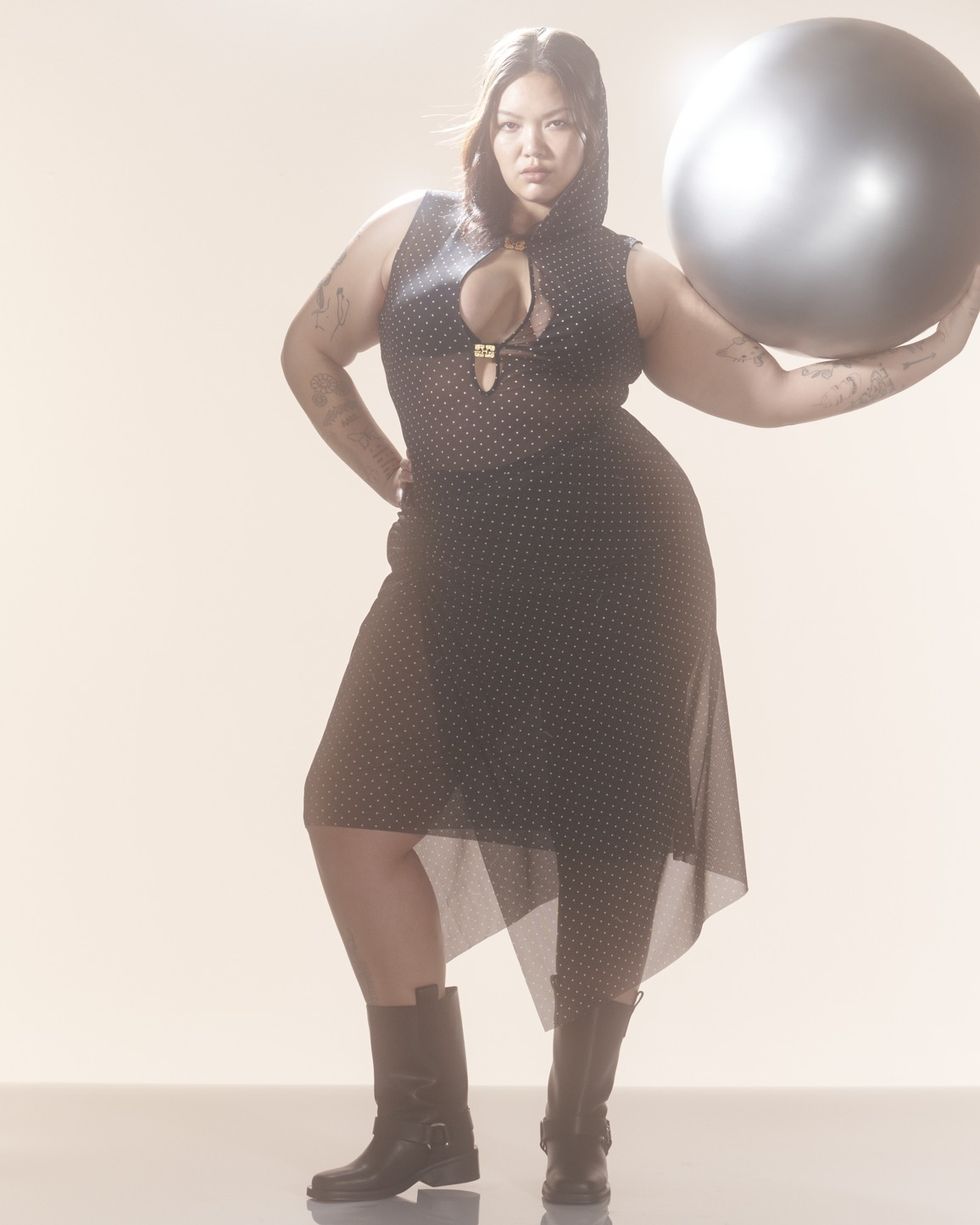a woman in a black dress holding a large white balloon