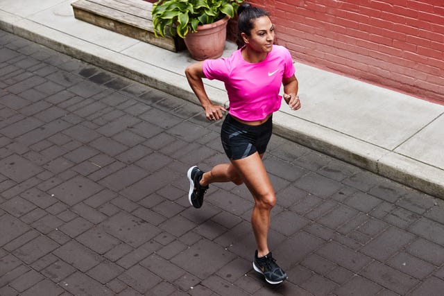 a woman running on a brick path