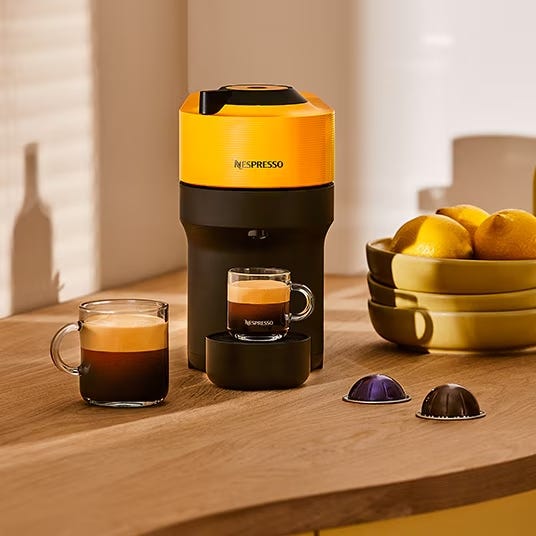 nespresso coffee machine with espresso cups and coffee capsules on a countertop