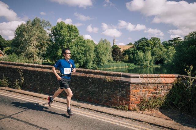 runner participating in a race on a road beside a river