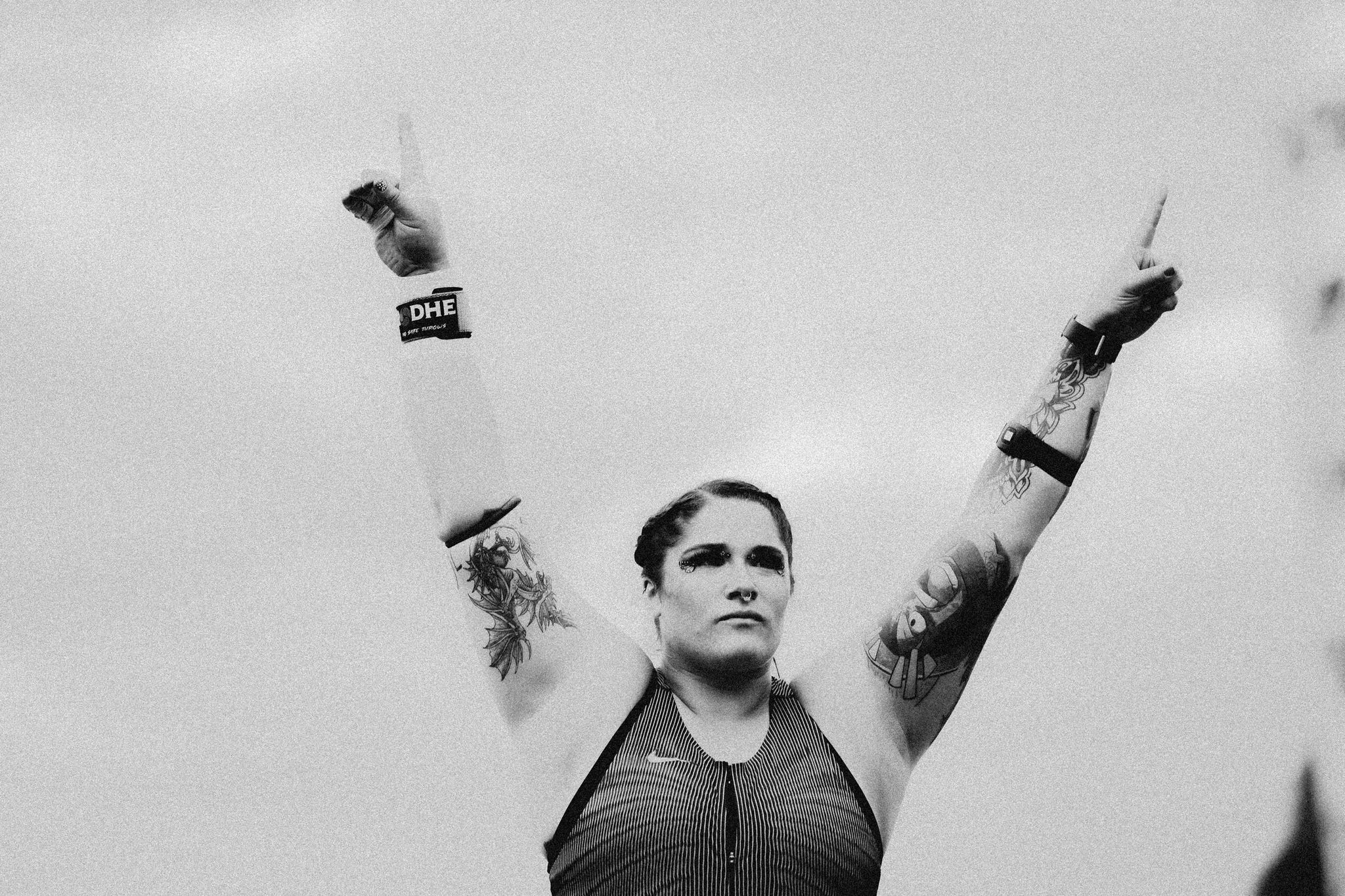 a woman track and field athlete raises her arms in celebration