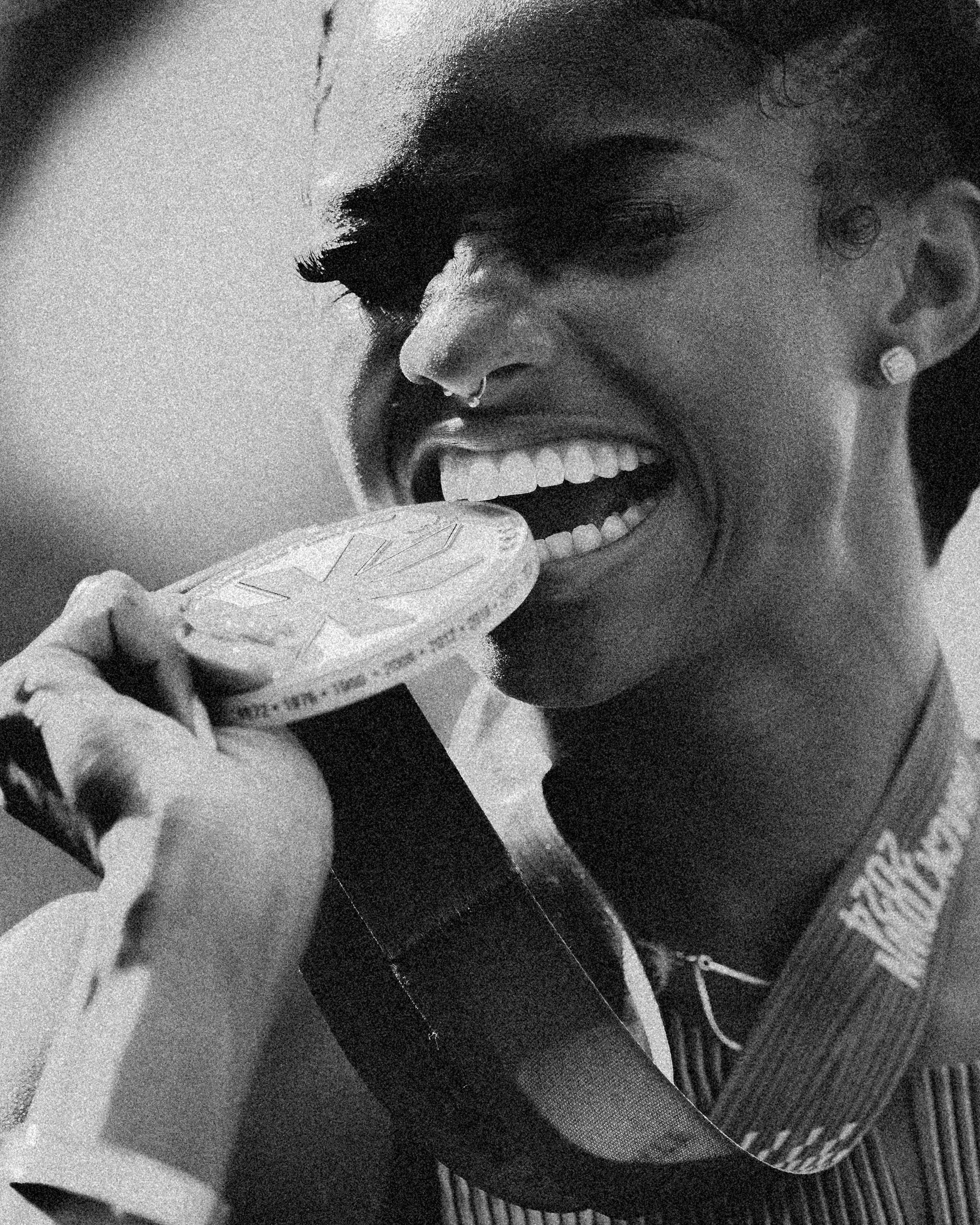 a woman bites a medal