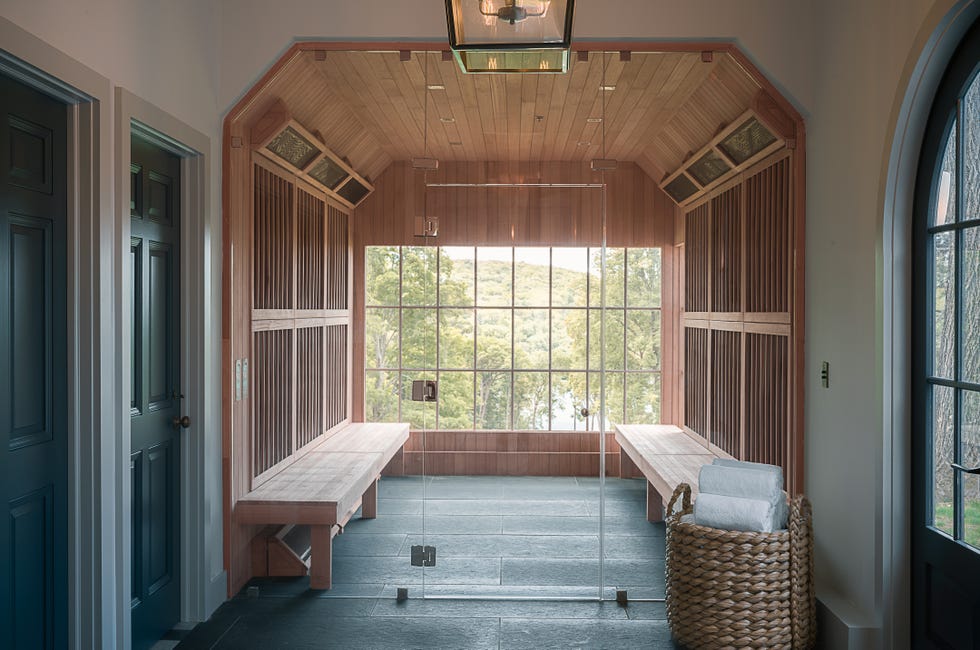 interior of a wooden saunalike room with large windows and benches