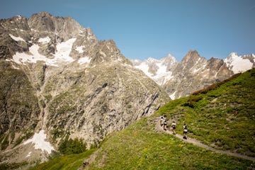 some runners on a trail against the backdrop of some mountains