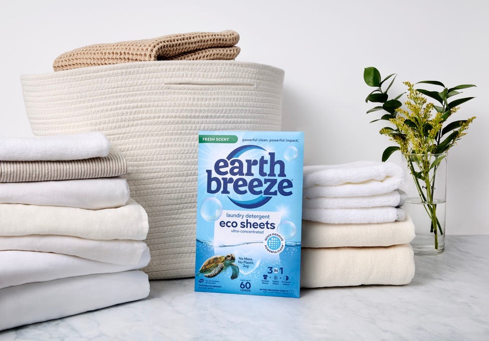 ecofriendly laundry detergent sheets with stacked towels and decorative plant