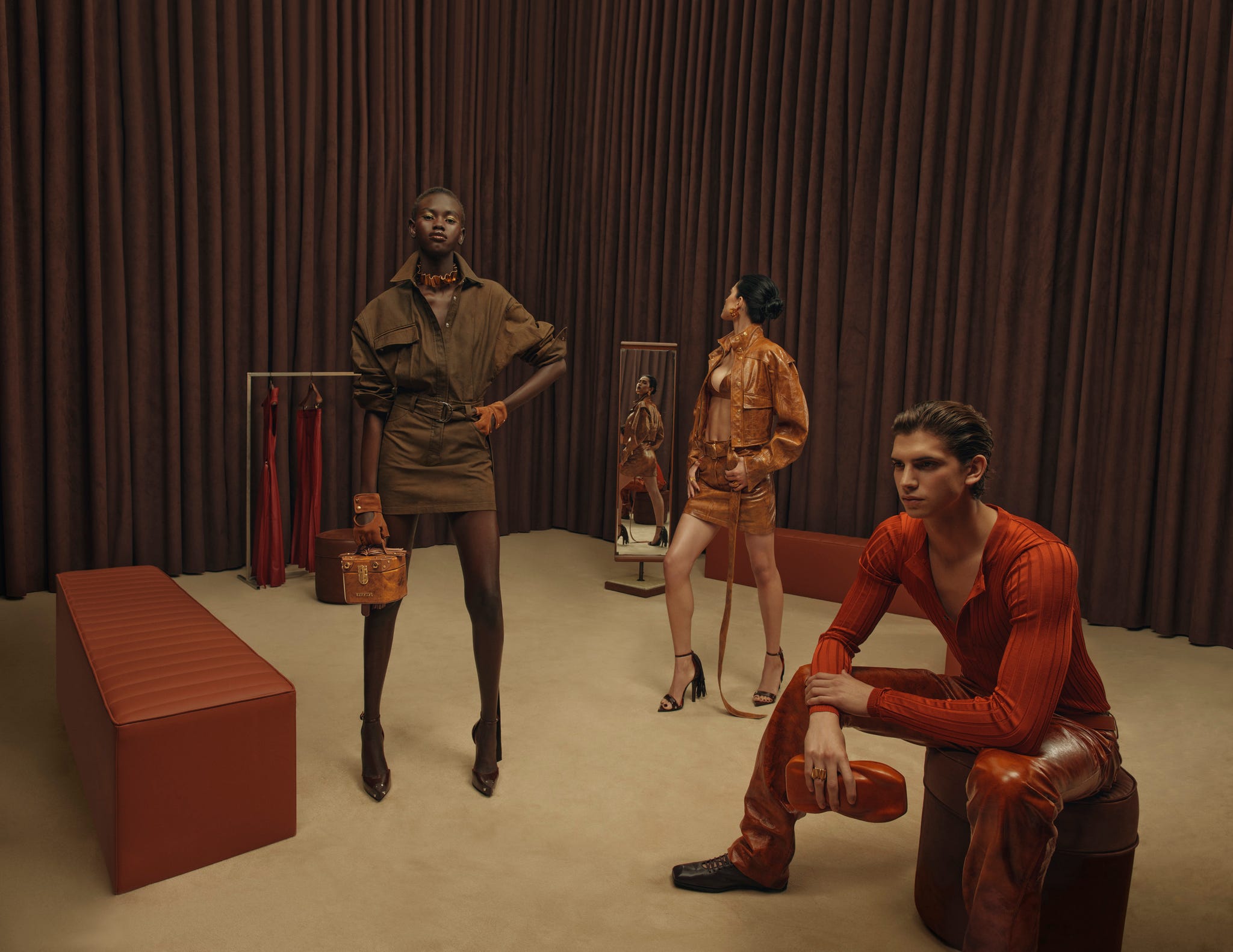 fashion showcase featuring three models and modern attire in a styled room