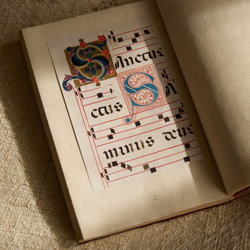 an open book displaying medieval sheet music with colorful illuminated initials