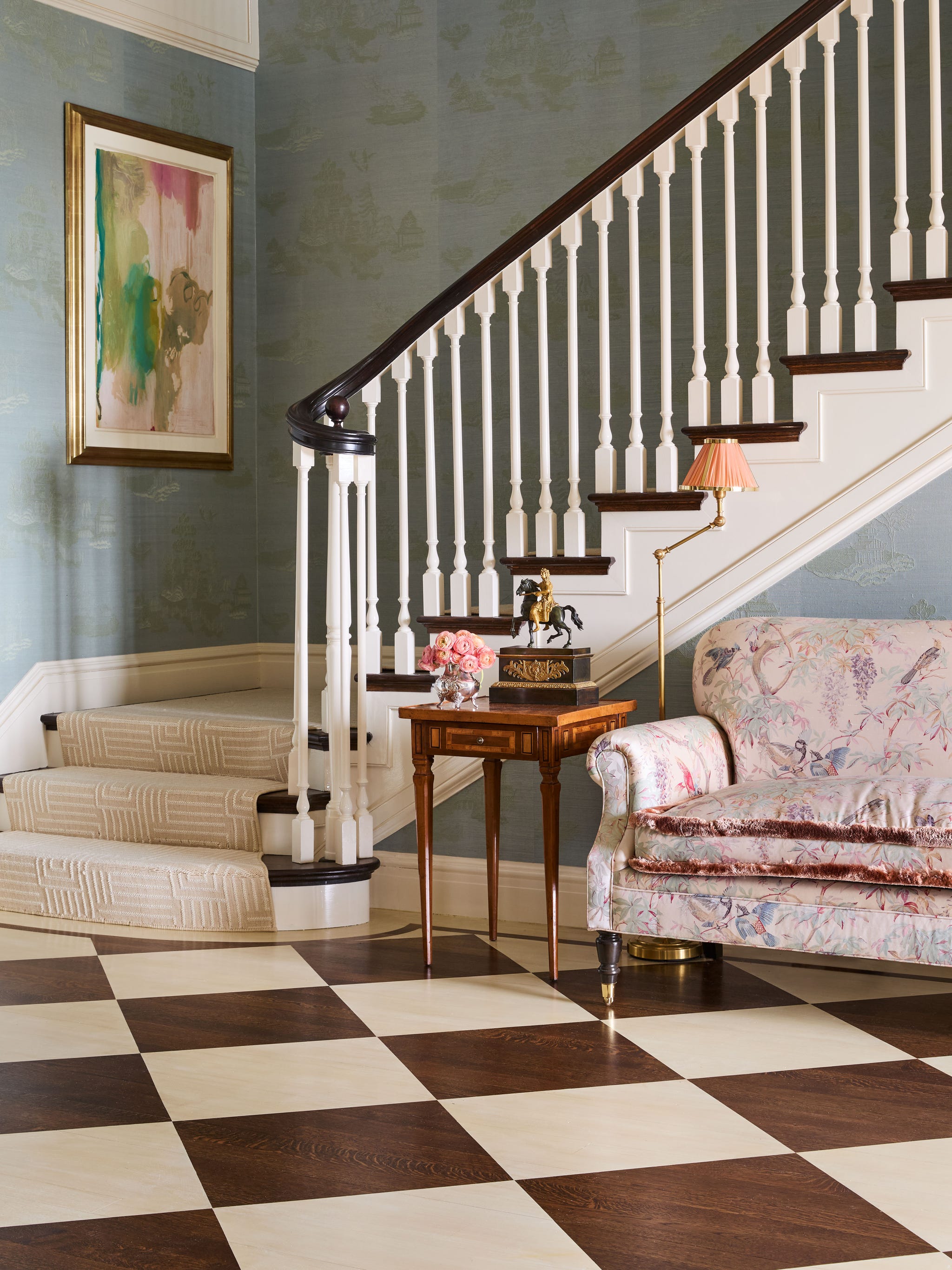 elegant foyer with a staircase and floral sofa