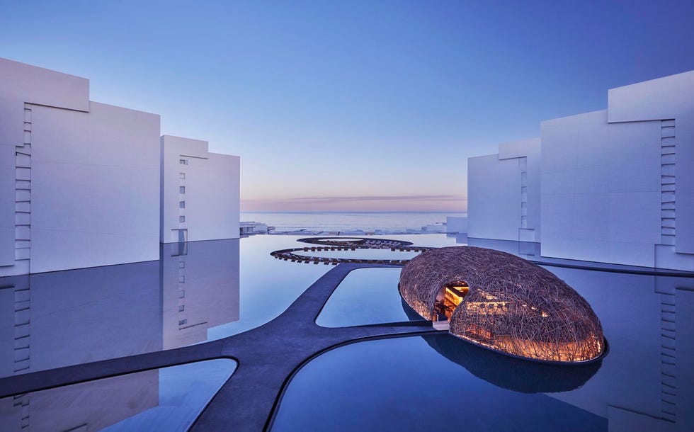 modern architectural design featuring a unique structure and a reflective pool