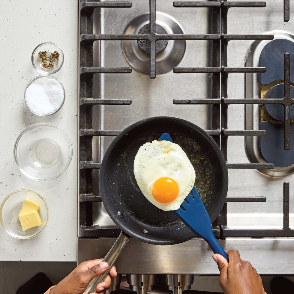 cooking food on a stovetop with ingredients arranged nearby
