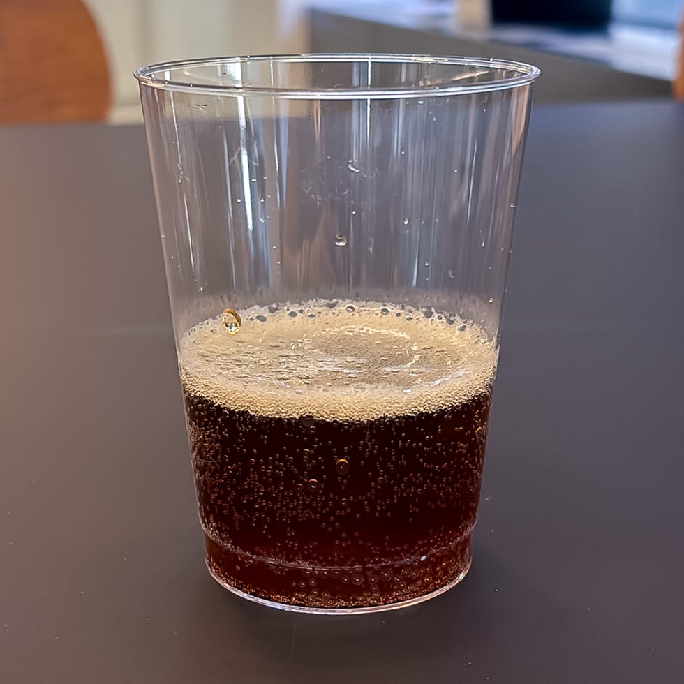 clear plastic cup filled with dark fizzy beverage