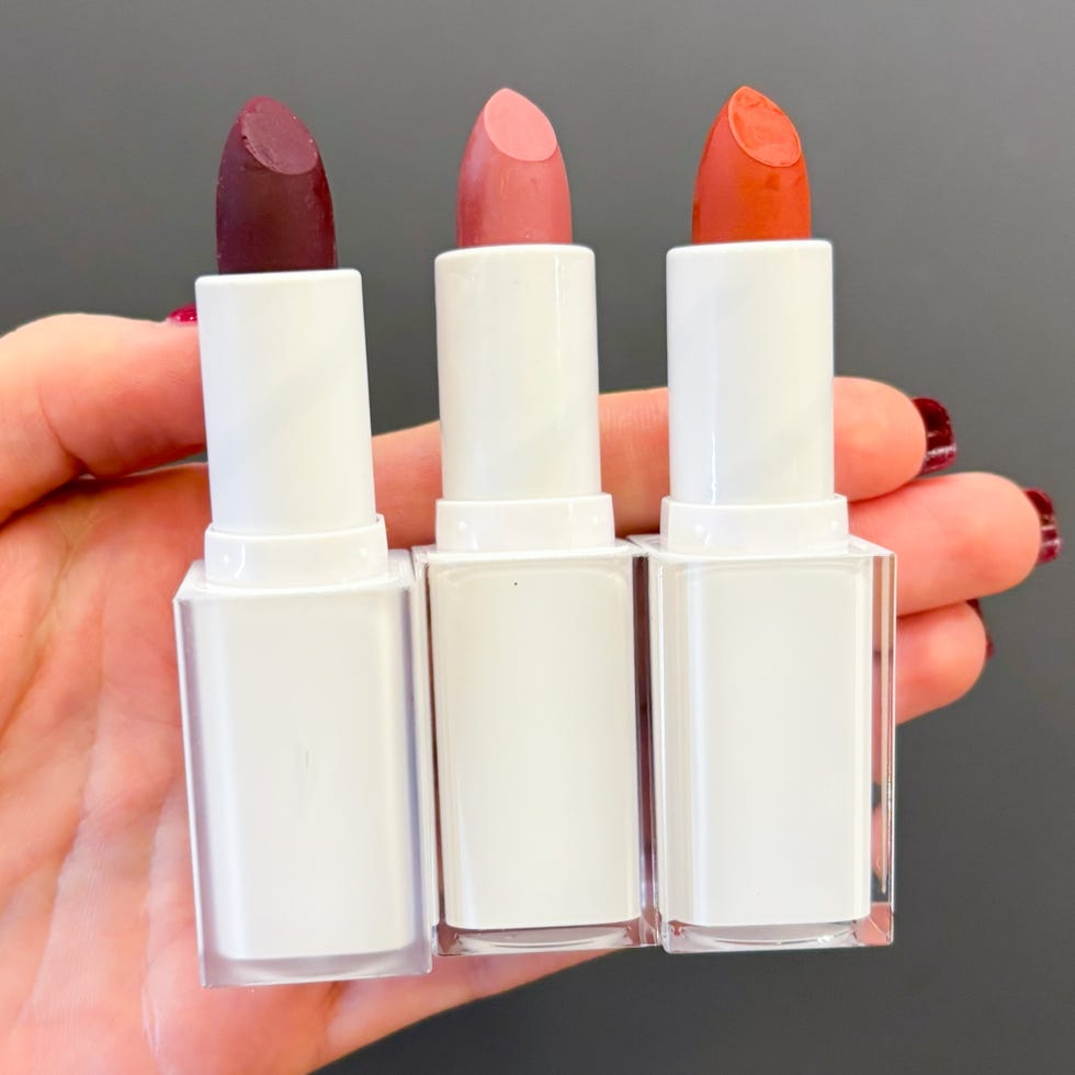 three lipsticks in varying colors held in a hand