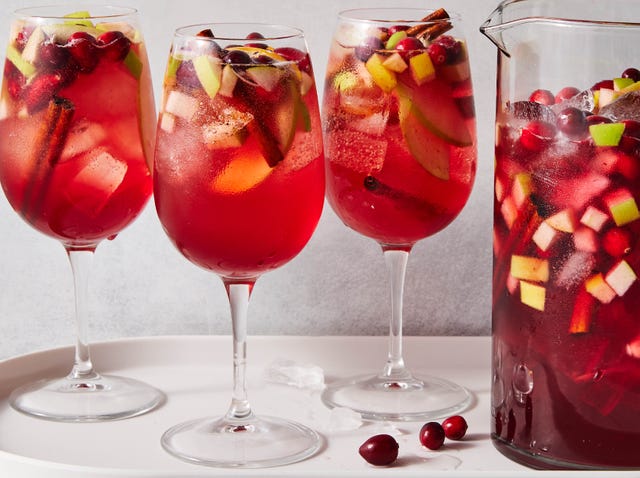 three glasses of sangria next to a pitcher of sangria